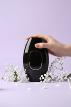 Hand holding VELLIZ device with baby's breath